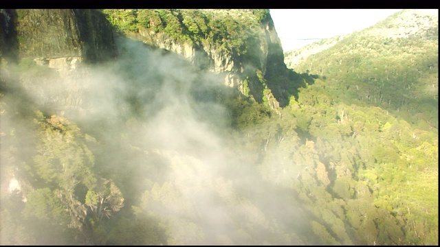 登山者从瀑布附近的悬崖上攀爬而下。视频素材