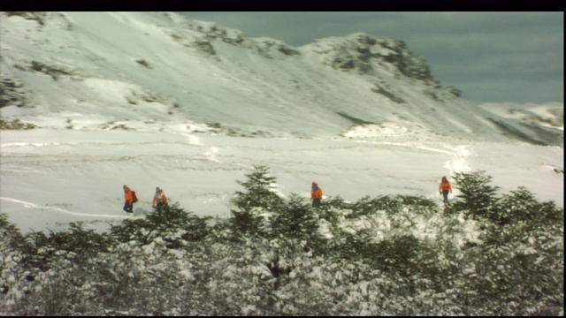 徒步旅行者艰难地穿越一座雪山。视频素材