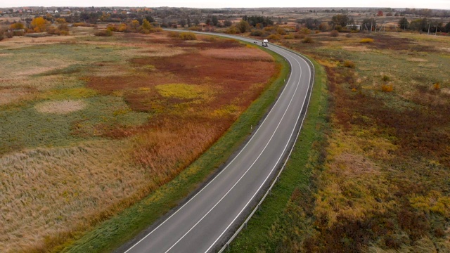 鸟瞰图飞行在令人惊叹的秋天自然和道路运行通过风景如画的乡村。路在秋景航拍。秋日的汽车驾驶道路穿过五彩缤纷的风景。视频素材