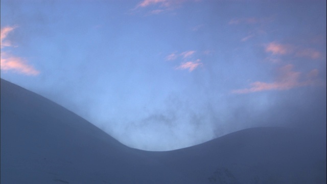 雾从白雪覆盖的山上升起。视频素材