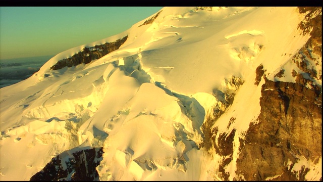 登山运动员沿着一条小径攀登一座雪山。视频素材