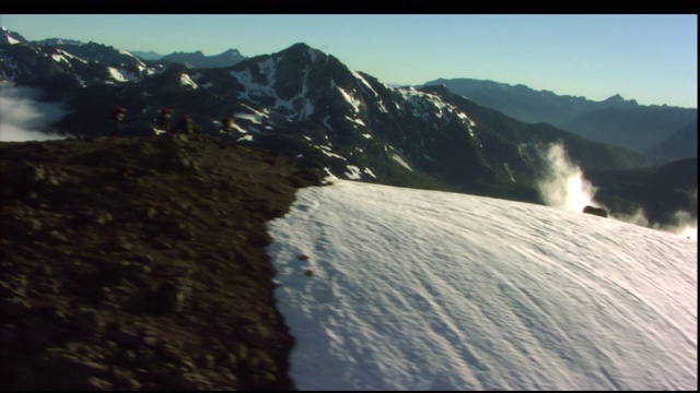 一队人沿着积雪的山脊徒步旅行。视频素材