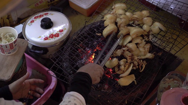 在船上烤鱿鱼的女士。泰国的旅游景点。视频素材