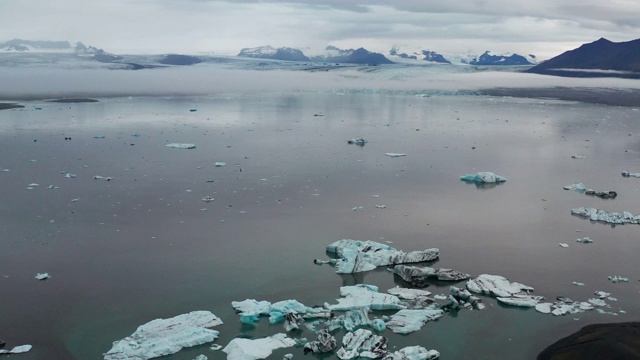 4K航拍Jokulsarlon礁湖的冰山与戏剧性的云视频素材