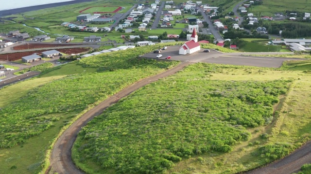 冰岛南部Vik i Myrdal的4K航拍镜头。田野上盛开的羽扇豆和夏天的镇上教堂。视频素材