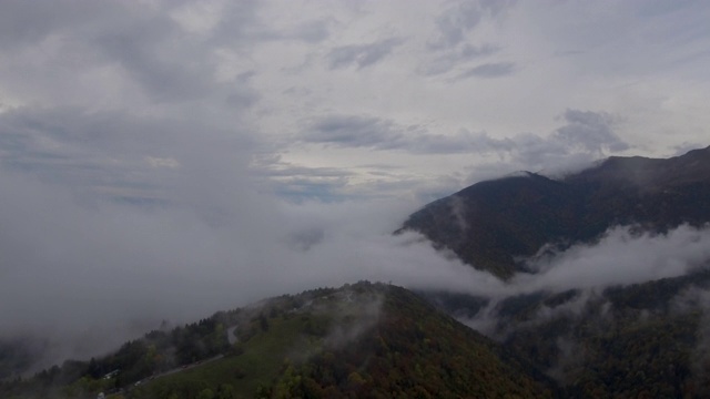 无人机镜头的飞行通过一些低云，薄雾和雾在高山秋季森林和山谷。视频素材