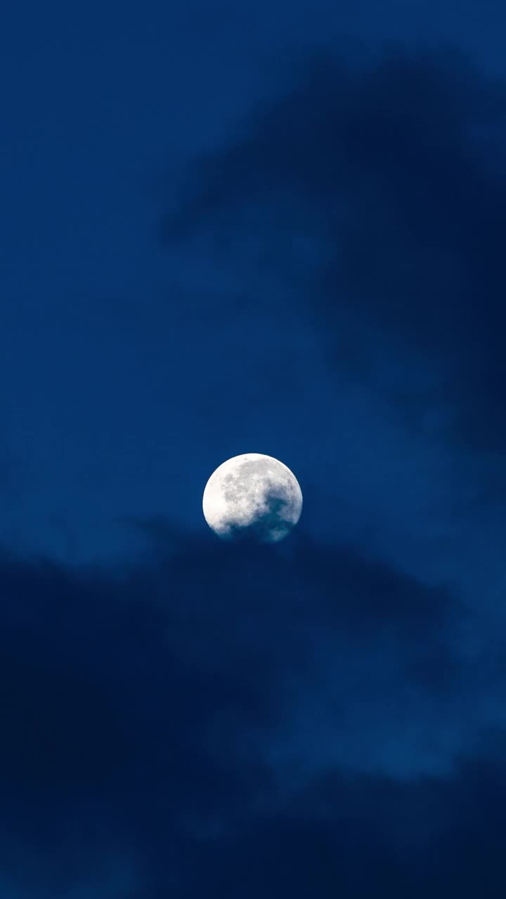 夜晚黎明前深蓝色天空中满月的垂直时间间隔视频素材