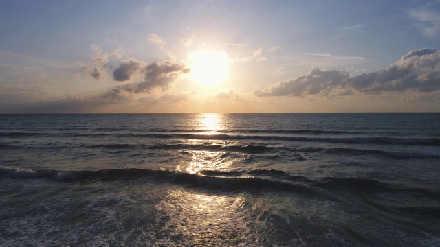 海上日出。海浪冲刷着海滩上的沙子。视频素材