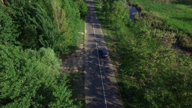 在乡村公路上行驶的汽车。鸟瞰图汽车转向郊区道路视频素材