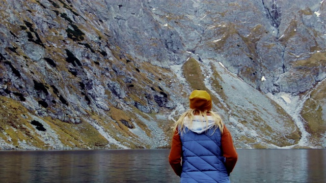 女旅行者欣赏山、湖和山的景色。视频素材