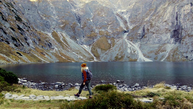 女旅行者欣赏山、湖和山的景色。视频素材