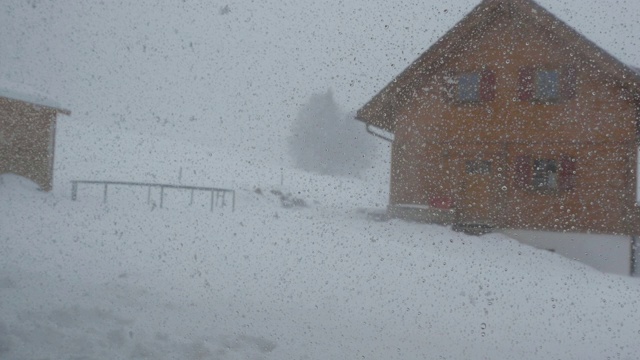 村庄暴风雪透过窗户，湿漉漉的雪花视频素材