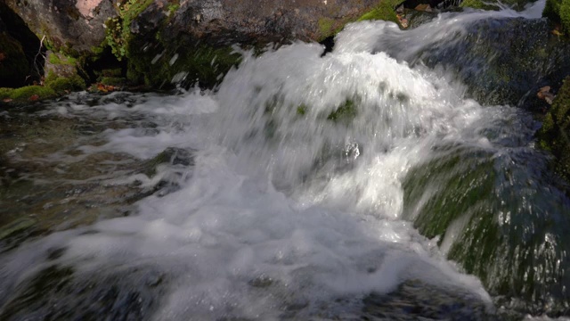 崎岖的山溪与水晶干净和清澈的水飞溅从山上的冰川流动视频素材