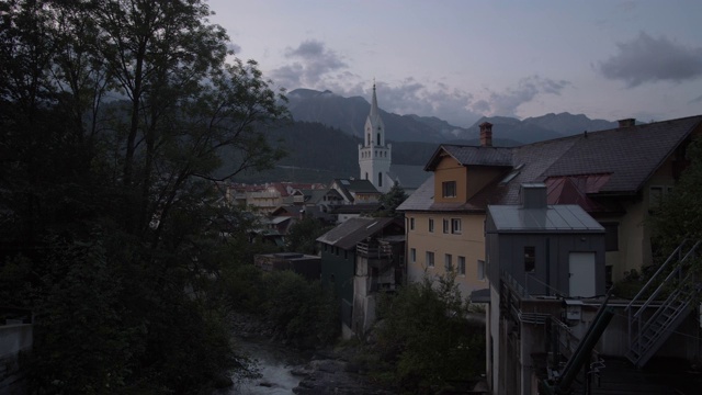 拍摄从河流到传统建筑和福音教堂的黄昏，Schladming, Styria，奥地利阿尔卑斯山，奥地利，欧洲视频素材