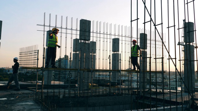 建筑工人们在建筑工地用统一的金属结构施工。视频素材