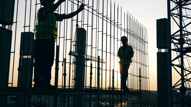 人们在建筑工地用金属杆工作。视频素材