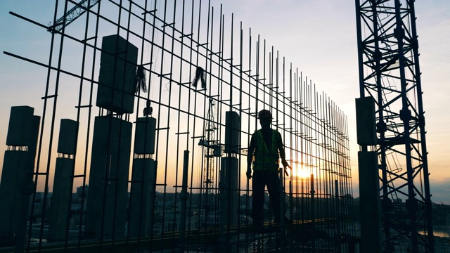 男人们在一个建筑工地上工作，背景是天空。视频素材