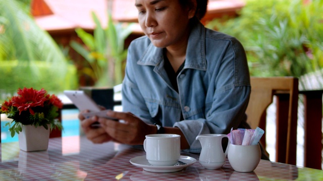 一名女子在咖啡店用智能手机用信用卡付款。视频素材