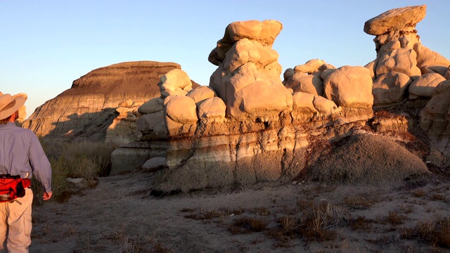 人类在新墨西哥州Bisti De-Na-Zin荒野探索受侵蚀的白垩纪砂岩峰顶视频素材