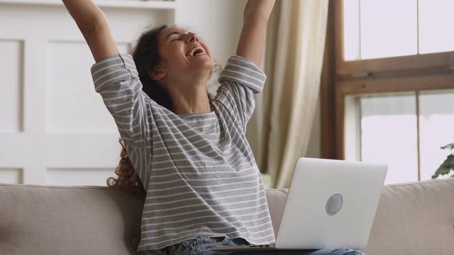 兴高采烈的年轻女子赢家看着笔记本电脑庆祝网上胜利视频素材