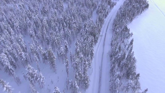 冬季，欧洲芬兰拉普兰托拉西皮湖被雪覆盖的道路上的无人机视频素材