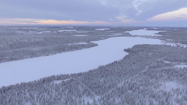 冬季景观和被雪覆盖的树木附近托拉西比湖(Torassieppi Lake, Toras-Sieppi Jarvi)日落，芬兰拉普兰，芬兰，欧洲视频素材