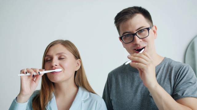 男人和女人在家里看着相机微笑着刷牙的肖像视频素材