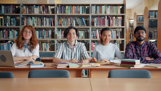 年轻学生坐在图书馆微笑着看着相机的肖像视频素材