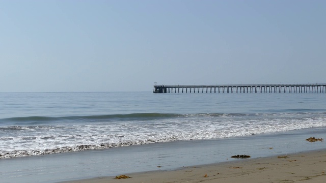 4K看一个长木码头，海浪冲上海岸的圣巴巴拉海岸视频素材