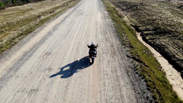 骑着大摩托车在乡村公路上，航拍视频素材