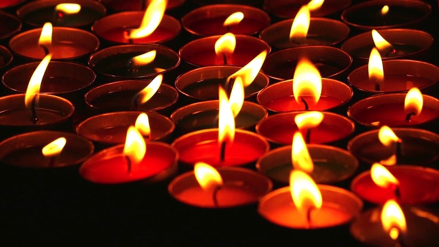 以蜡烛为背景，缓慢地用平底锅升起火来敬拜佛陀视频素材