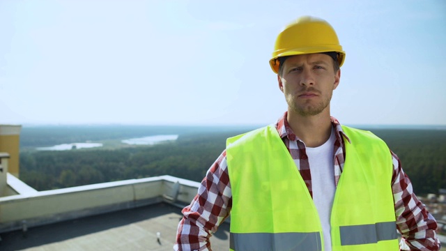 专业男性建筑工人在头盔看相机，建筑行业，工作视频素材