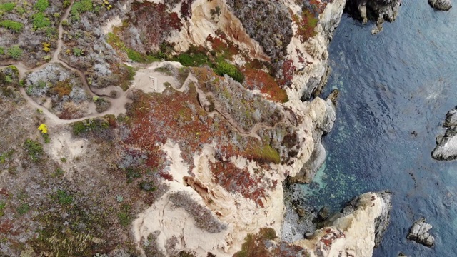 飞过悬崖附近的陆地，深入大海，倾斜着，显示出一片悬崖和大山。视频下载