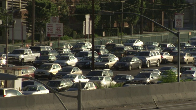 在临街道路和高速公路上，车辆挤满了车流附近的停车场。视频素材