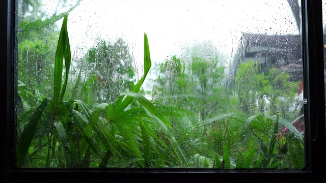 近距离拍摄的雨滴落下来一个清晰的车窗在雷雨暴雨视频素材