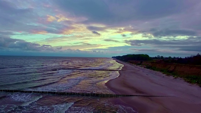 无人机飞越海岸，夕阳西下，夕阳的色彩强烈视频素材