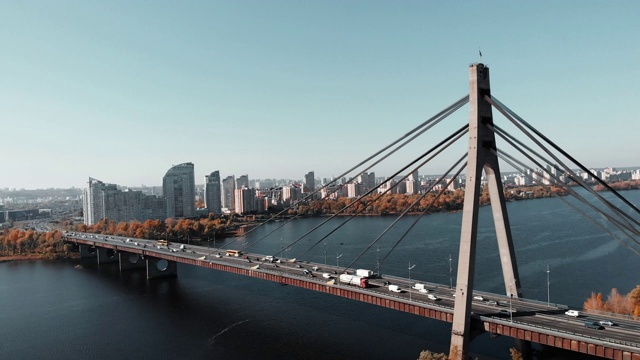 混凝土桥横跨大都市的河流。无人机在大城市大桥附近飞行，背景是高层建筑。市中心河流和桥梁鸟瞰图。基辅,乌克兰视频素材