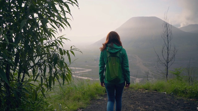 日出时，女人看着布罗莫火山视频素材