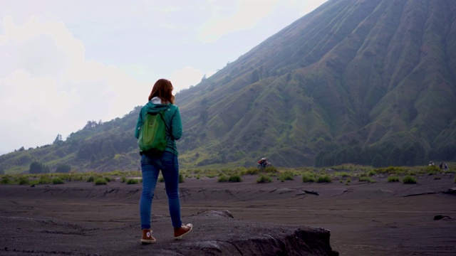 日出时在布罗莫火山附近散步的女人视频素材