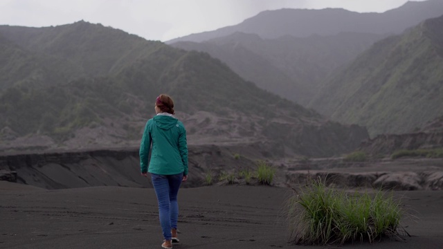 日出时在布罗莫火山附近散步的女人视频素材