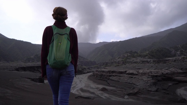 日出时在布罗莫火山附近散步的女人视频素材