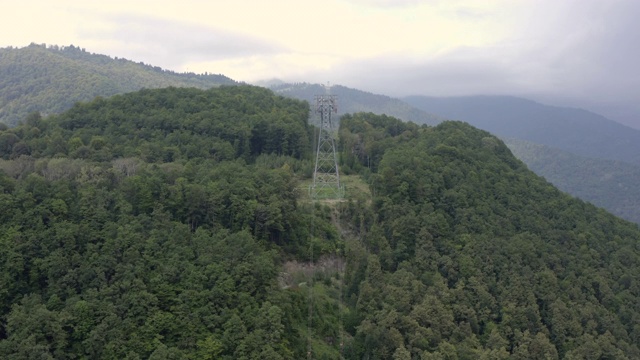 无人机观绿山索道。避暑山庄缆车客舱在缆车上行驶。空中景观缆车道山间覆盖夏季森林视频素材