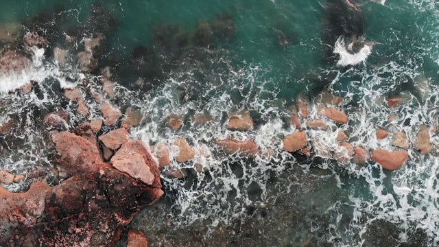 大浪撞击海石的特写鸟瞰图。在刮风的日子海浪视频素材