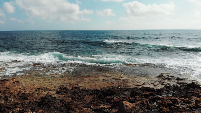 航拍的海浪拍打着岩石峭壁的海滩。暴风雨的海浪冲击着布满岩石的海滩。无人驾驶飞机。视频素材