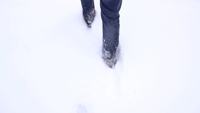 男人穿着冬靴在深雪中行走，慢动作，天气视频素材