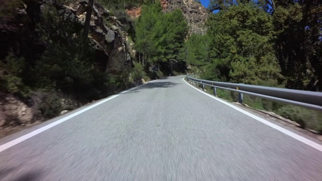 前车行驶在高速公路上没有交通，蜿蜒曲折的道路穿过崎岖的地形，蓝天白云，Rincón德阿德穆兹，巴伦西亚社区视频素材