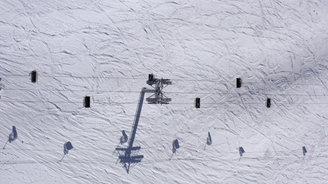 鸟瞰图滑雪电梯，用于运输滑雪者和滑雪板在雪坡上。无人机在滑雪场冬山缆车缆车上同步飞行视频素材