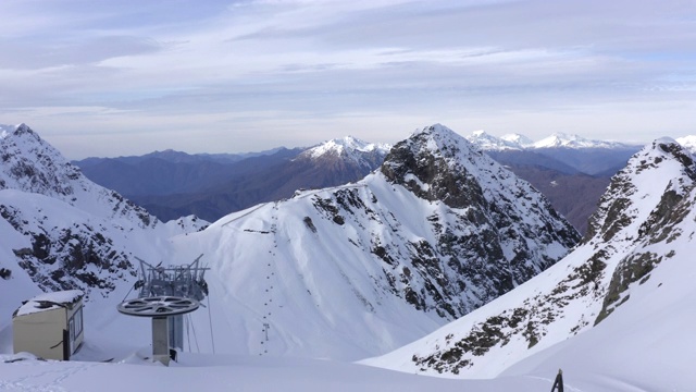 有雪峰的高山和冬季旅游胜地的滑雪缆车。空中景观冬季高山和电梯的滑雪者和滑雪板。无人机观看雪山度假村视频素材