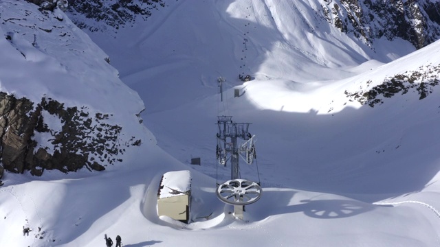 滑雪者站在滑雪场的雪坡上，背景是滑雪缆车。空中景观雪山度假胜地。滑雪、单板滑雪、滑雪旅游和登山。冬季极限运动视频素材