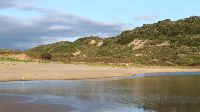 在南非海岸泻湖和沙丘上方移动的云的时间流逝视频素材